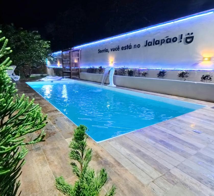 Una piscina frente a un edificio por la noche. en Pousada Ame Jalapão, en Mateiros