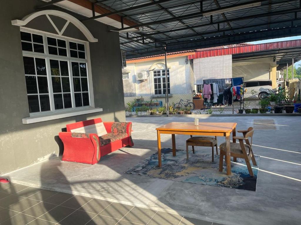 パリト・ブンターにあるHomestay MamaTwinz, musslimstay, Parit Buntarの建物の前にパティオ(テーブル、椅子付)