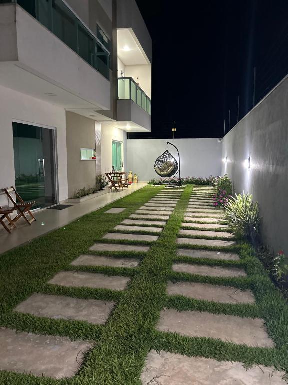 a walkway with grass on the side of a building at La casa de Luna in Guaibim