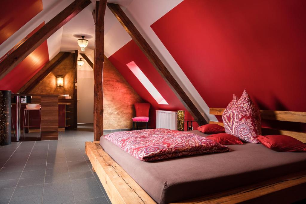 a bedroom with a bed with a red wall at Lustra Stundenhotel - Adults Only in Landshut