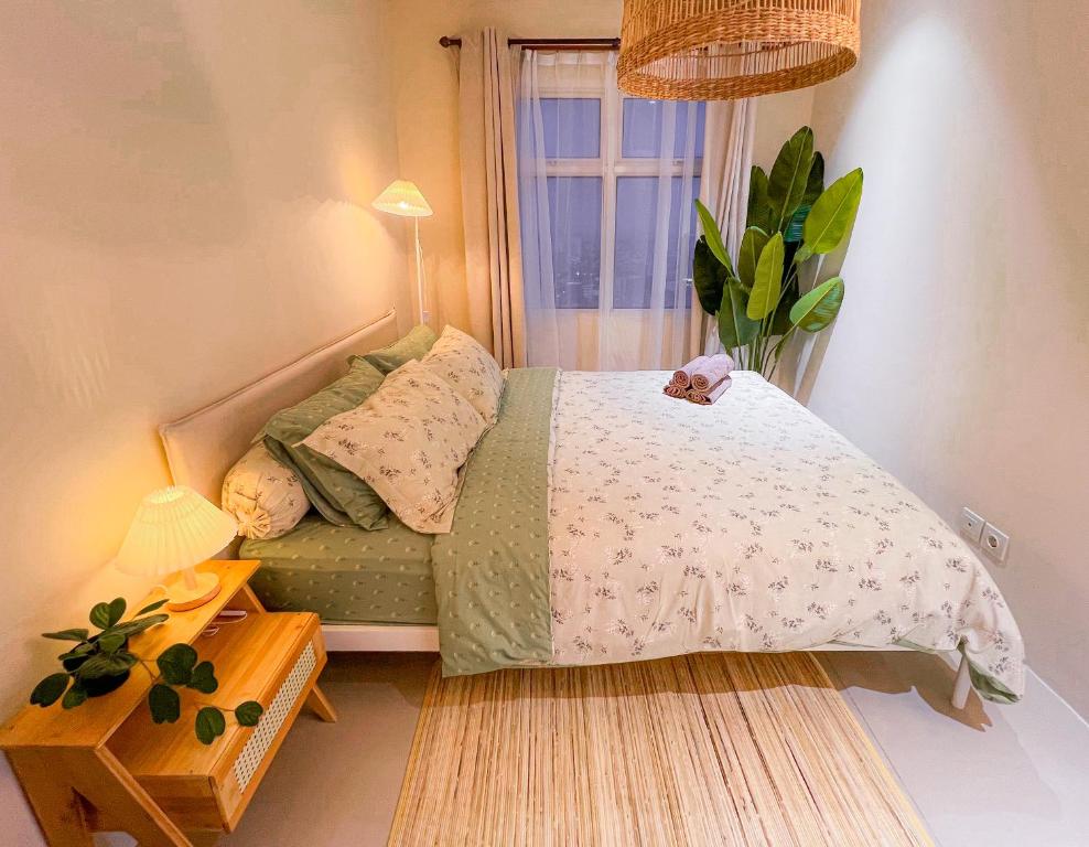 a small bedroom with a bed and a window at Madison Park Apartment HOMEY by Host Jess in Jakarta