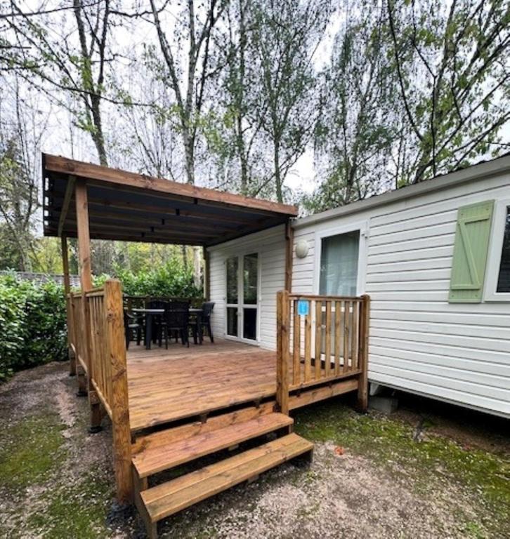 - une terrasse en bois sur le côté d'une maison dans l'établissement Camping paradis de la plage, à Saint-Cirq-Lapopie