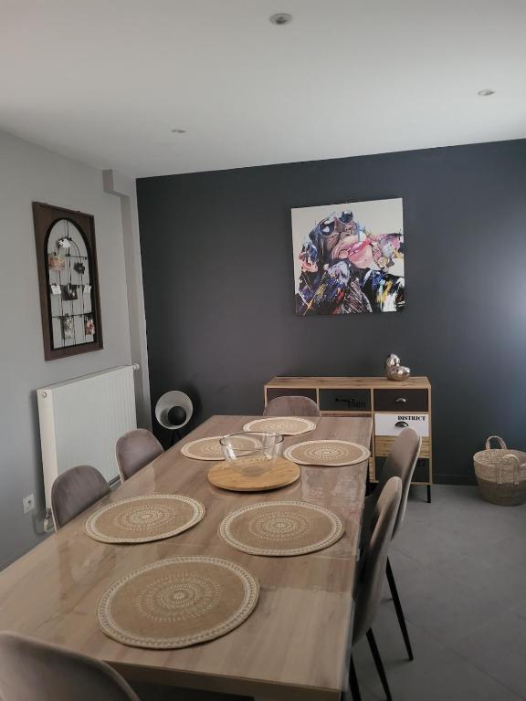 une salle à manger avec une table et des chaises en bois dans l'établissement Bel appartement en RDC avec parking, à Chassieu