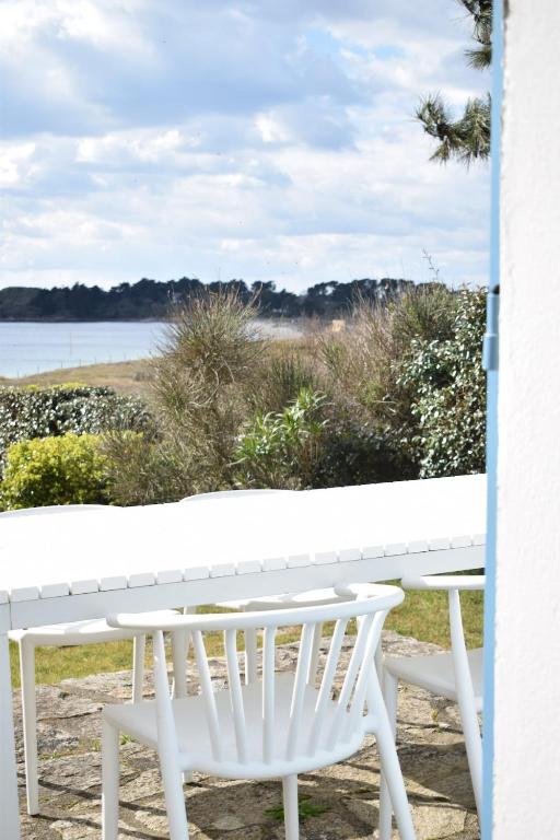 un banc blanc assis sur un porche surplombant l'eau dans l'établissement Maison Kermor, à Arzon