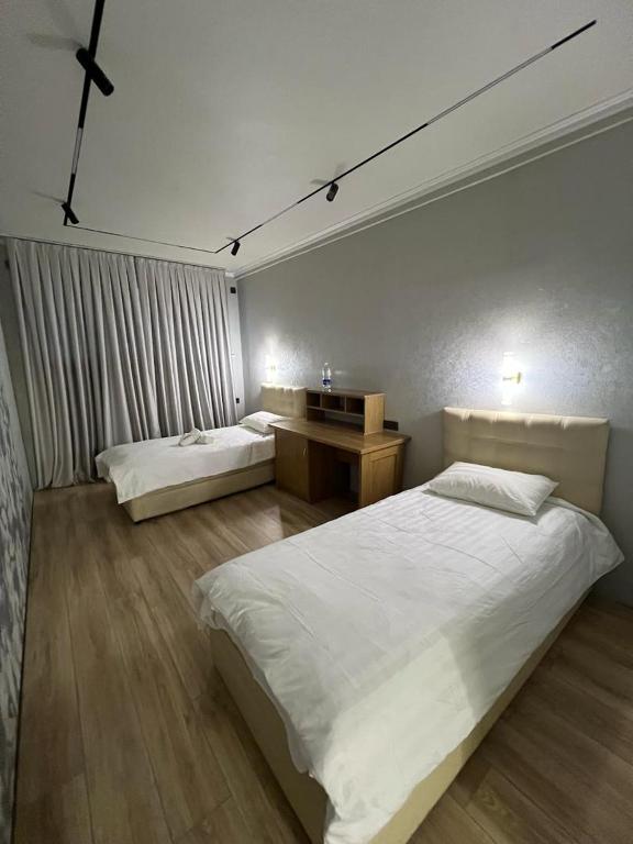 a bedroom with two beds and a desk in it at Достук in Karachiy