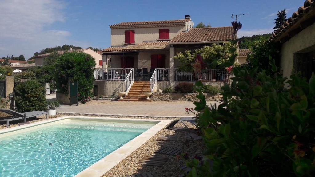 une maison avec une piscine devant une maison dans l'établissement Maison familiale avec piscine, à Châteauneuf-du-Pape