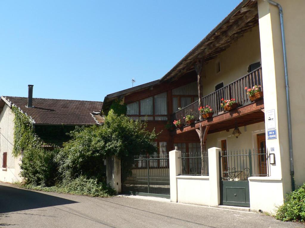 ein Gebäude mit einem Balkon mit Blumen darauf in der Unterkunft Le Relais de St Jean in Saint-Jean-de Niost