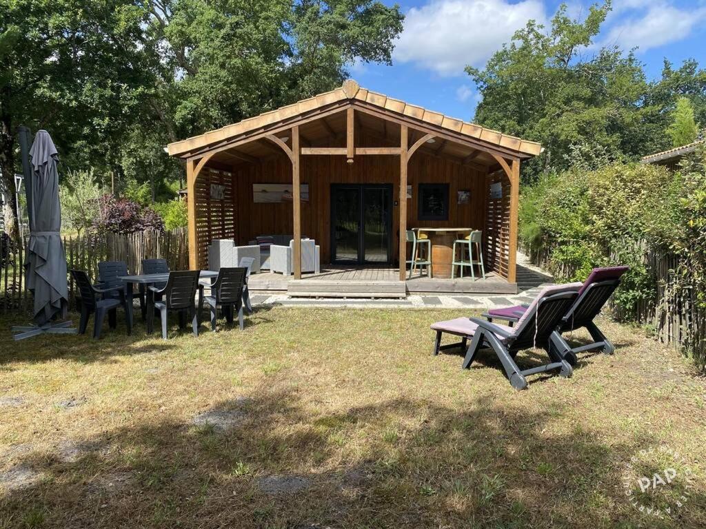 ein Pavillon mit Stühlen und einem Tisch in einem Hof in der Unterkunft Chalet VIP Ostéa au coeur du Bassin d'Arcachon in La Teste-de-Buch