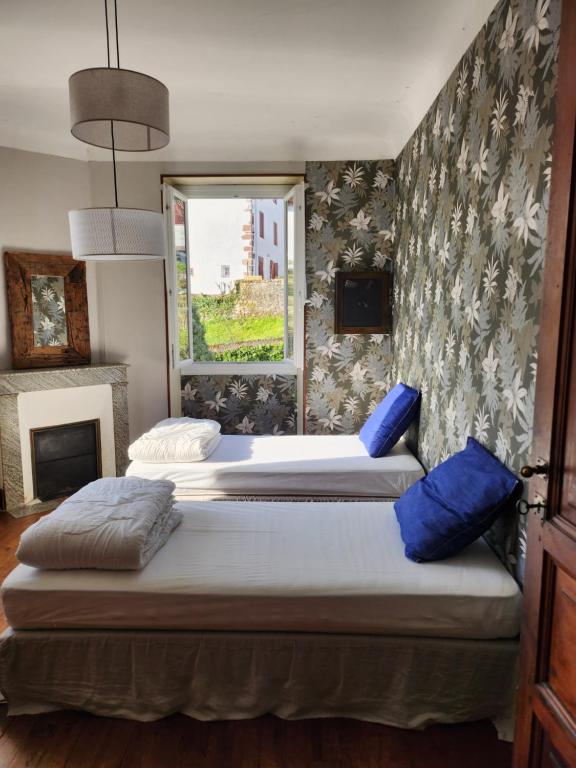 two beds in a room with a window at Gite Compostella in Saint-Jean-Pied-de-Port
