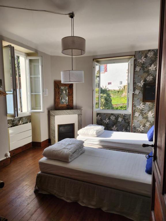 a bedroom with two beds and a fireplace at Gite Compostella in Saint-Jean-Pied-de-Port