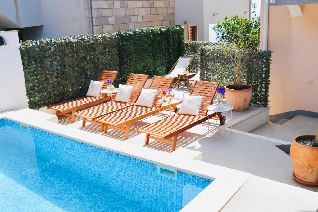 a group of chairs next to a swimming pool at Marojica Apartments 2 in Cavtat