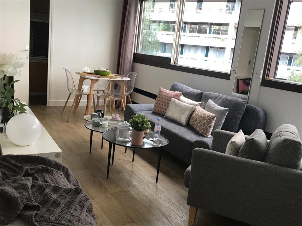 un salon avec un canapé et une table dans l'établissement Grand studio fonctionnel, calme et ensoleillé, à Paris