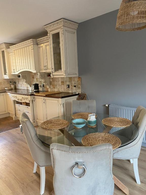 a kitchen with a glass table and chairs and a counter at 160m piękny stylowy dwupoziomowy dom in Gdynia
