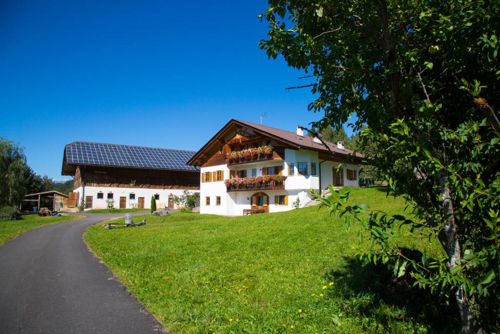 dom na trawiastym polu obok drogi w obiekcie Gastreinhof w mieście Meltina