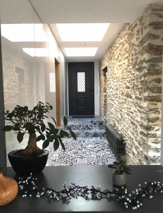 un couloir avec une porte noire et une plante en pot dans l'établissement Demeure Familiale Haut de Gamme 230m2 en Centre-Ville de Nantes Tramway à 2 min, à Nantes