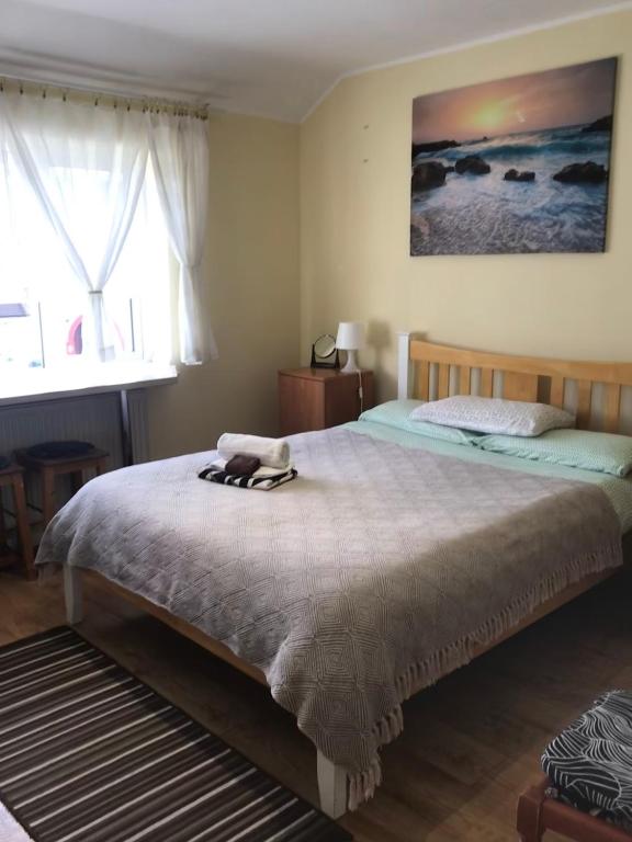 a bedroom with a bed with two slippers on it at Becontreelodge in Dagenham