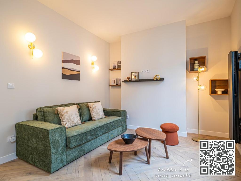 un salon avec un canapé vert et une table dans l'établissement OIQIA • Palace Hôtel • N°3, à Tours