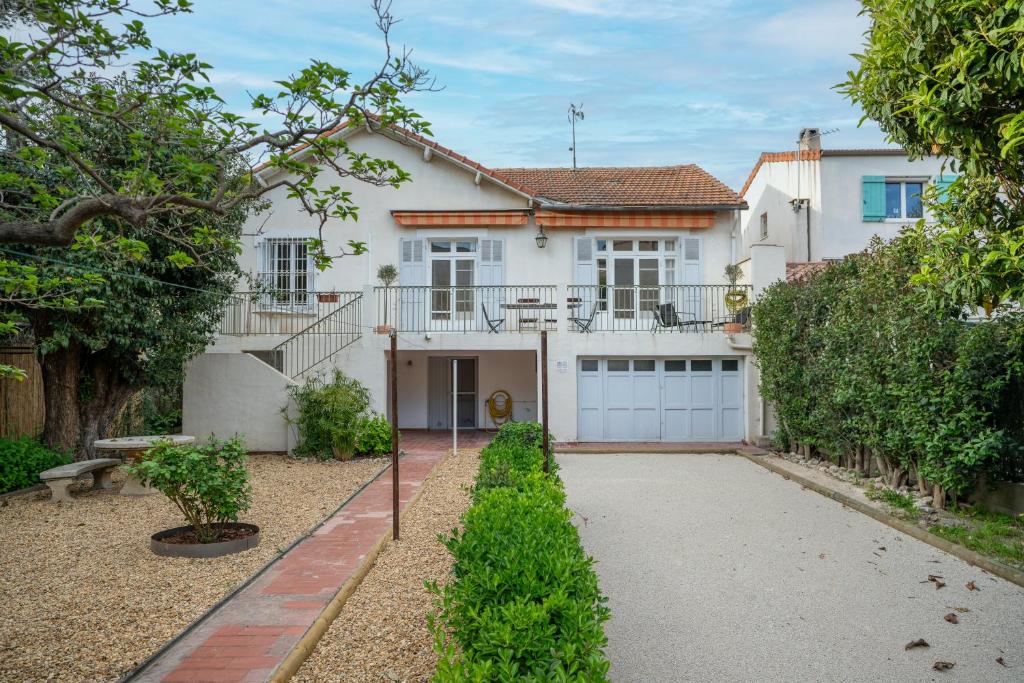 ein großes weißes Haus mit Garage in der Unterkunft Villa Maurel YourHostHelper in Arles