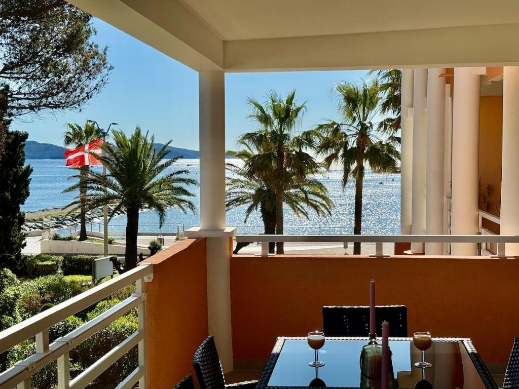 d'un balcon avec une table et une vue sur la plage. dans l'établissement stunning sea view, à Cavalaire-sur-Mer