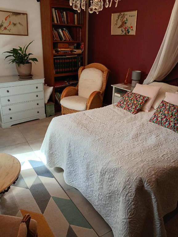 a bedroom with a large bed and a chair at La ruelle in Volonne