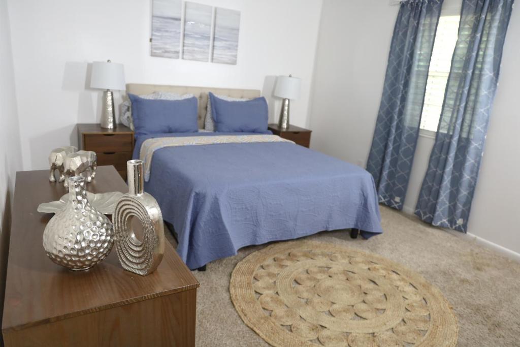 a bedroom with a bed with blue sheets and a table at 3 Bedroom Lake House With Garage in Tallahassee