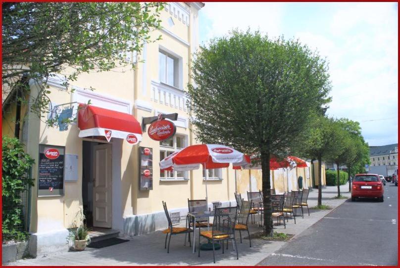フランチシュコヴィ・ラーズニェにあるPenzion U Modrého Slonaの歩道にテーブルと椅子とパラソルを配したレストラン