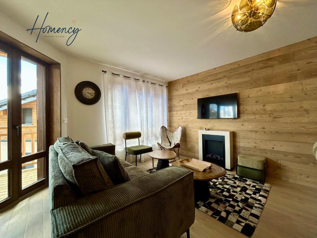 un salon avec un canapé et une cheminée dans l'établissement Homency - Résidence L'Expression D21, à L'Alpe-d'Huez