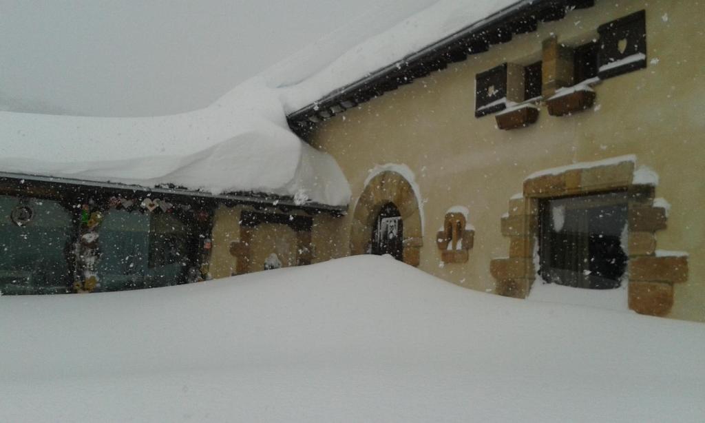 un tas de neige sur le côté d'une maison dans l'établissement Posada Rural Lindos Sueños, à La Lomba