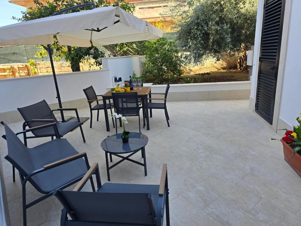 a patio with a table and chairs and an umbrella at Lemon House in Avola