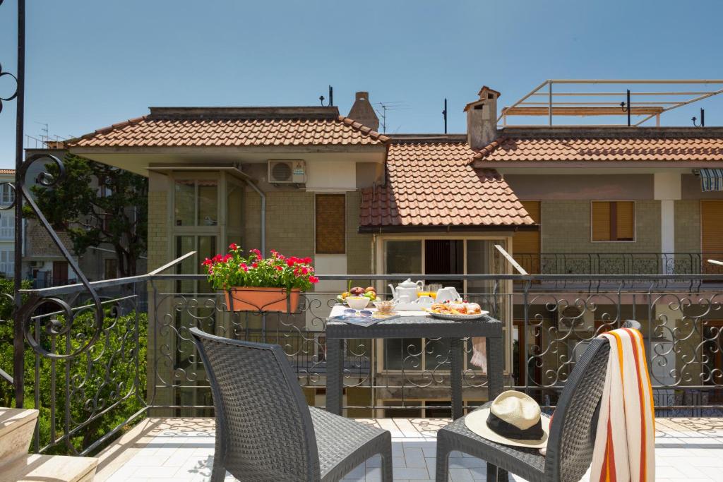 a balcony with a table and chairs and a house at DOUBLE HOUSE SORRENTO byBEACH in Sorrento