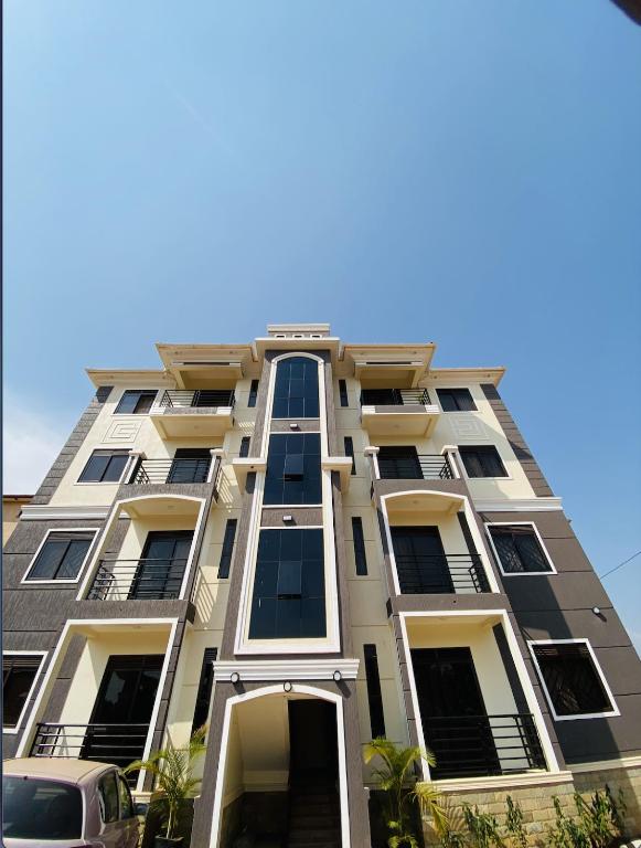 a tall building with windows and a car parked in front at The Cozy Nest in Kampala
