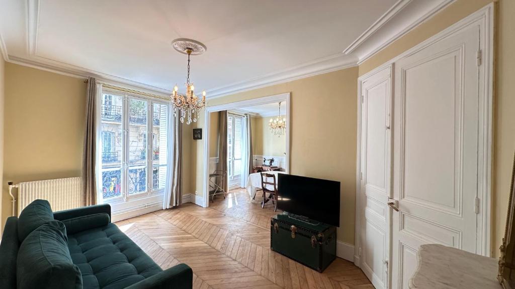 un salon avec un canapé et une télévision dans l'établissement Maison des Artistes, à Paris