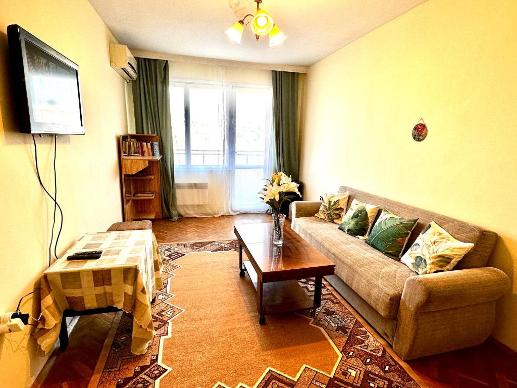 een woonkamer met een bank en een tafel bij Ssenyange City Apartment in Varna
