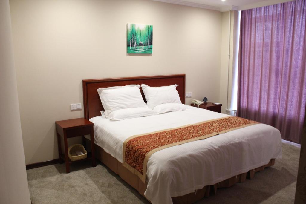 a bedroom with a large bed and a window at GreenTree Inn Jiangsu Nanjing Olympic Sports Center Express Hotel in Nanjing