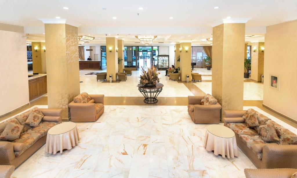 a lobby with couches and tables in a building at Ani Plaza Hotel in Yerevan