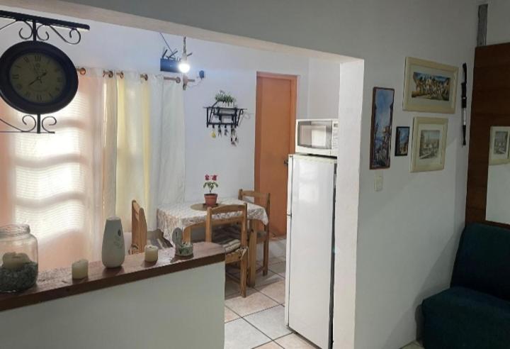a kitchen with a refrigerator and a table with a clock at Casa Color in Florida