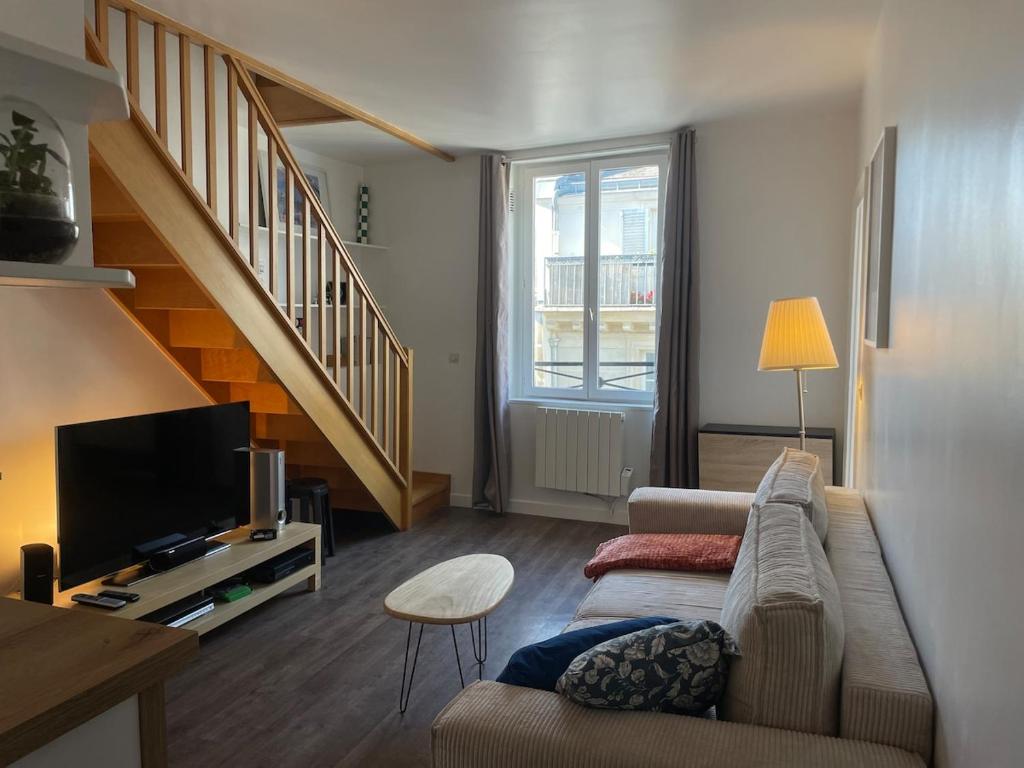 un salon avec un canapé et une télévision dans l'établissement Au cœur du marais, centre de Paris, à Paris