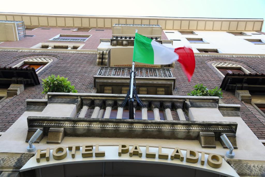 a flag flying on the facade of a hotel palacio at Hotel Palladio in Milan