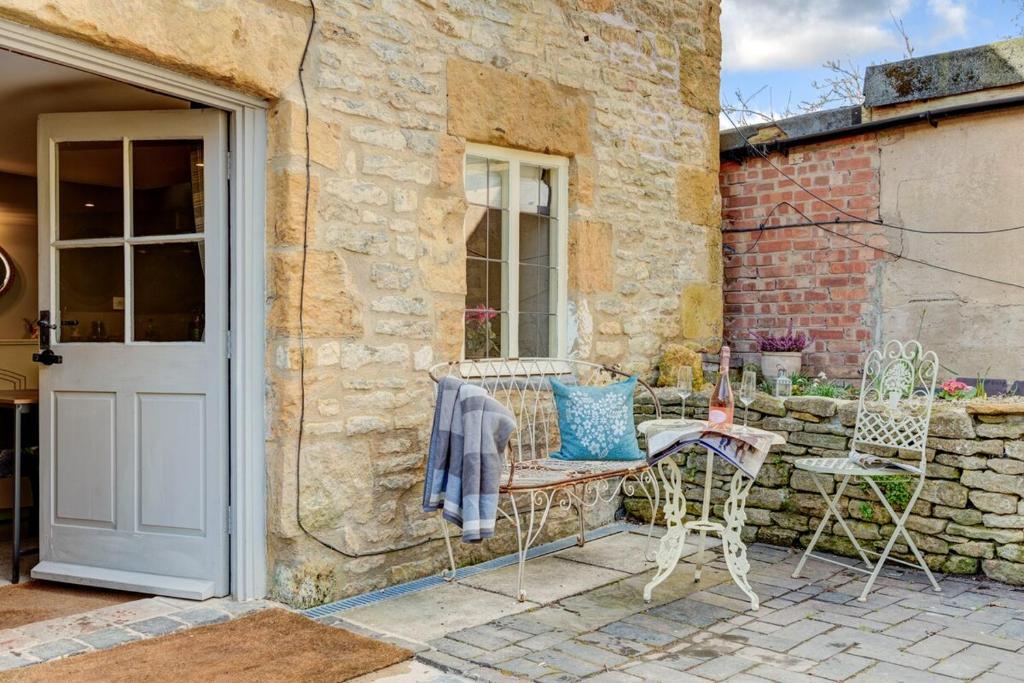 a patio with a table and chairs and a door at The Cotswolds Hidden Gem in Moreton in Marsh