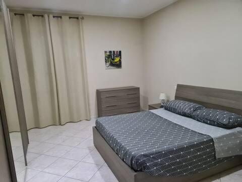 a bedroom with a bed and a dresser at Casadaema in Acerra