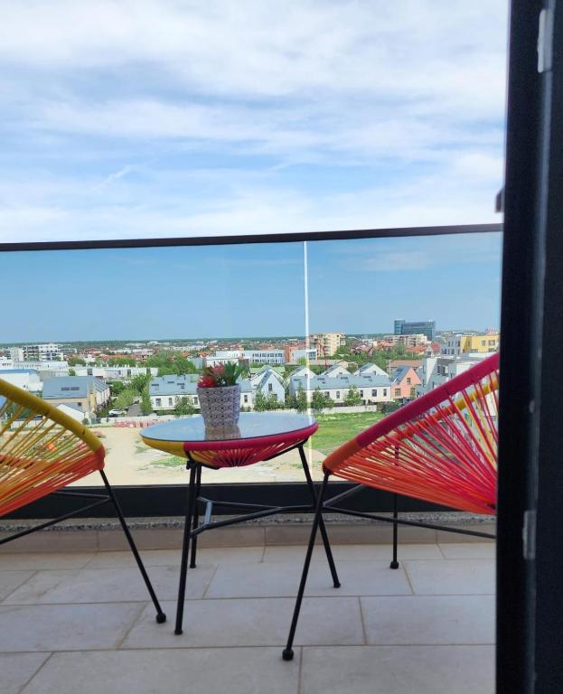 a table and two chairs on a balcony with a view at Primavera Pipera Plaza in Voluntari