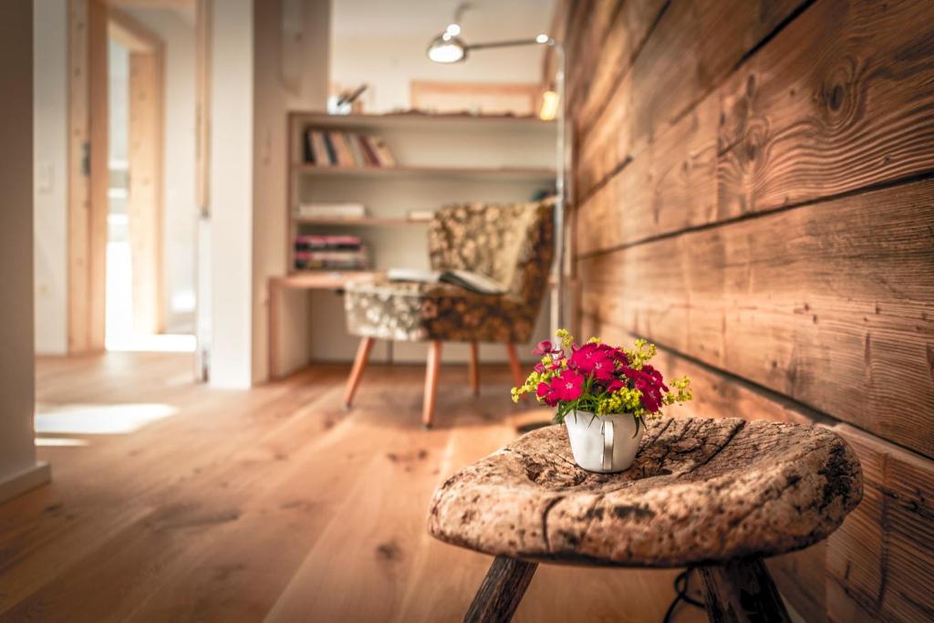 Cette chambre comprend une table avec des fleurs. dans l'établissement ALPENRAUM Ferienwohnungen Berchtesgaden, à Berchtesgaden