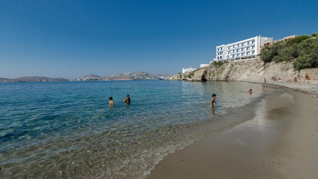 un grupo de personas de pie en el agua en una playa en Nikolas Hotel, en Parikia