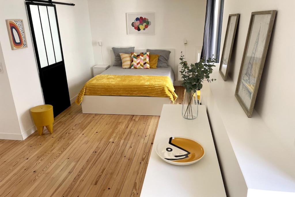 a small bedroom with a bed and a table at PETITE MAISON à 100M DE LA MER ET DU CENTRE VILLE in Concarneau