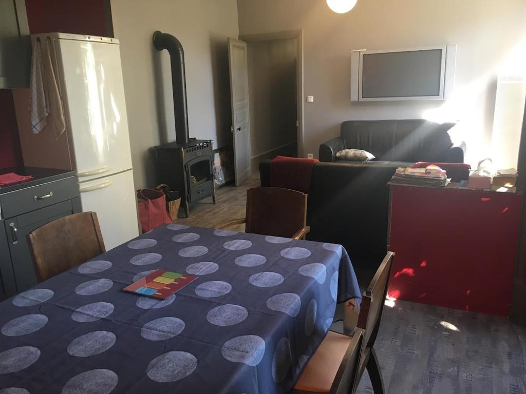 une cuisine et un salon avec une table et un chiffon bleu dans l'établissement Drôme provençale village house, à La Motte-Chalançon