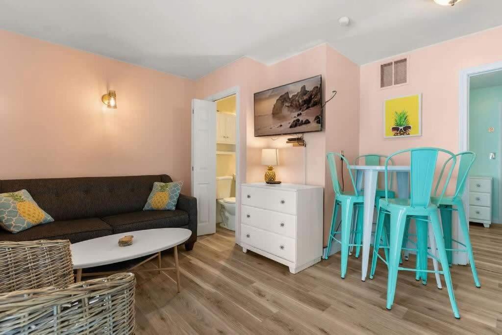 ein Wohnzimmer mit Sofa, Stühlen und einem Tisch in der Unterkunft Steps to Beach and Boardwalk Pineapple Retreat in Hampton
