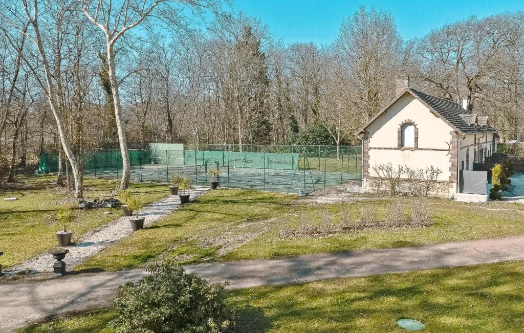 une petite maison blanche dans une cour avec une clôture dans l'établissement Maison Hortensias Avec Piscine, à Gien