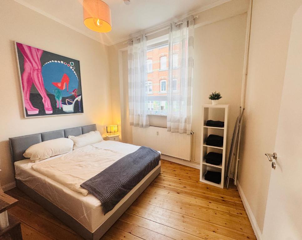 a bedroom with a bed and a painting on the wall at Kieler Hofquartier - zentral und gemütlich wohnen in Kiel