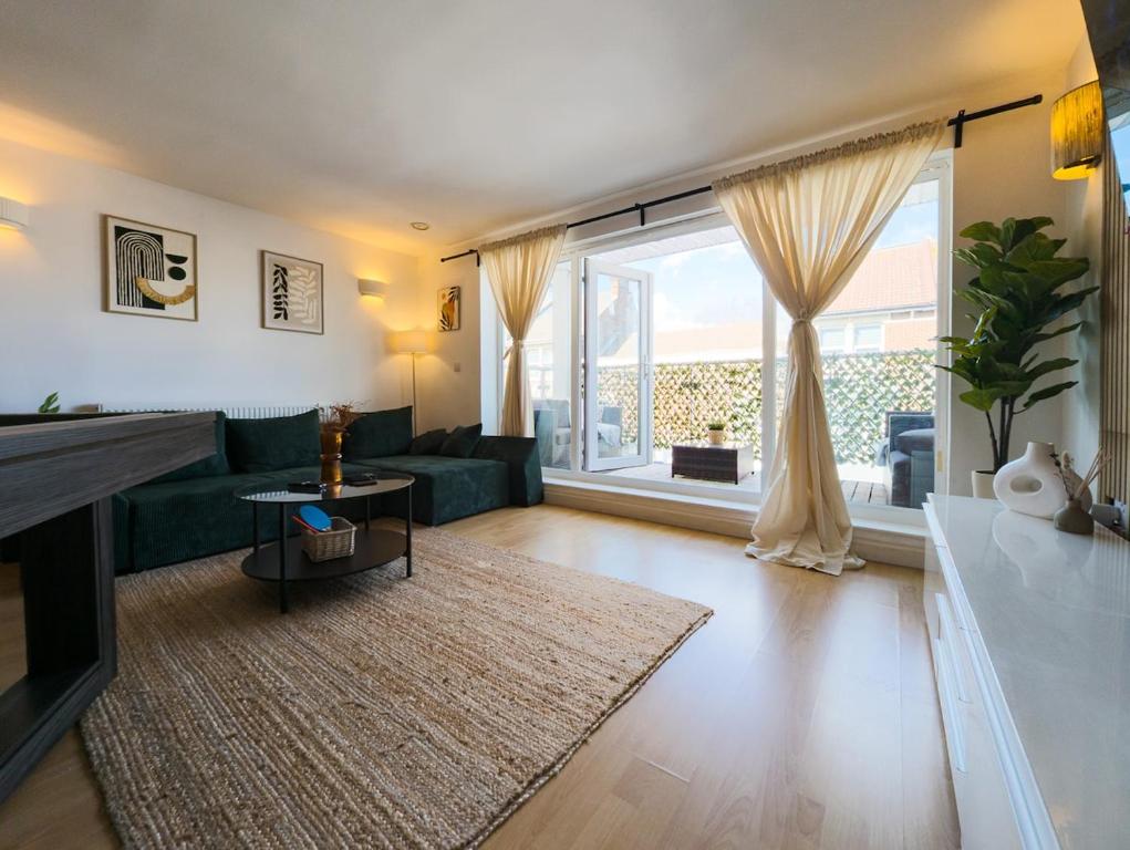 朴次茅斯Central Apt En Suites with Pool table and Private Balcony的客厅设有绿色沙发和大窗户