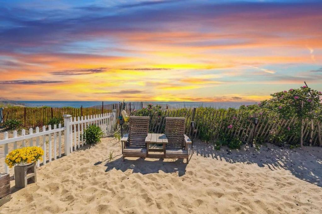 two chairs sitting on the sand on a beach at Beachfront Parking Salisbury Beach Retreat in Salisbury